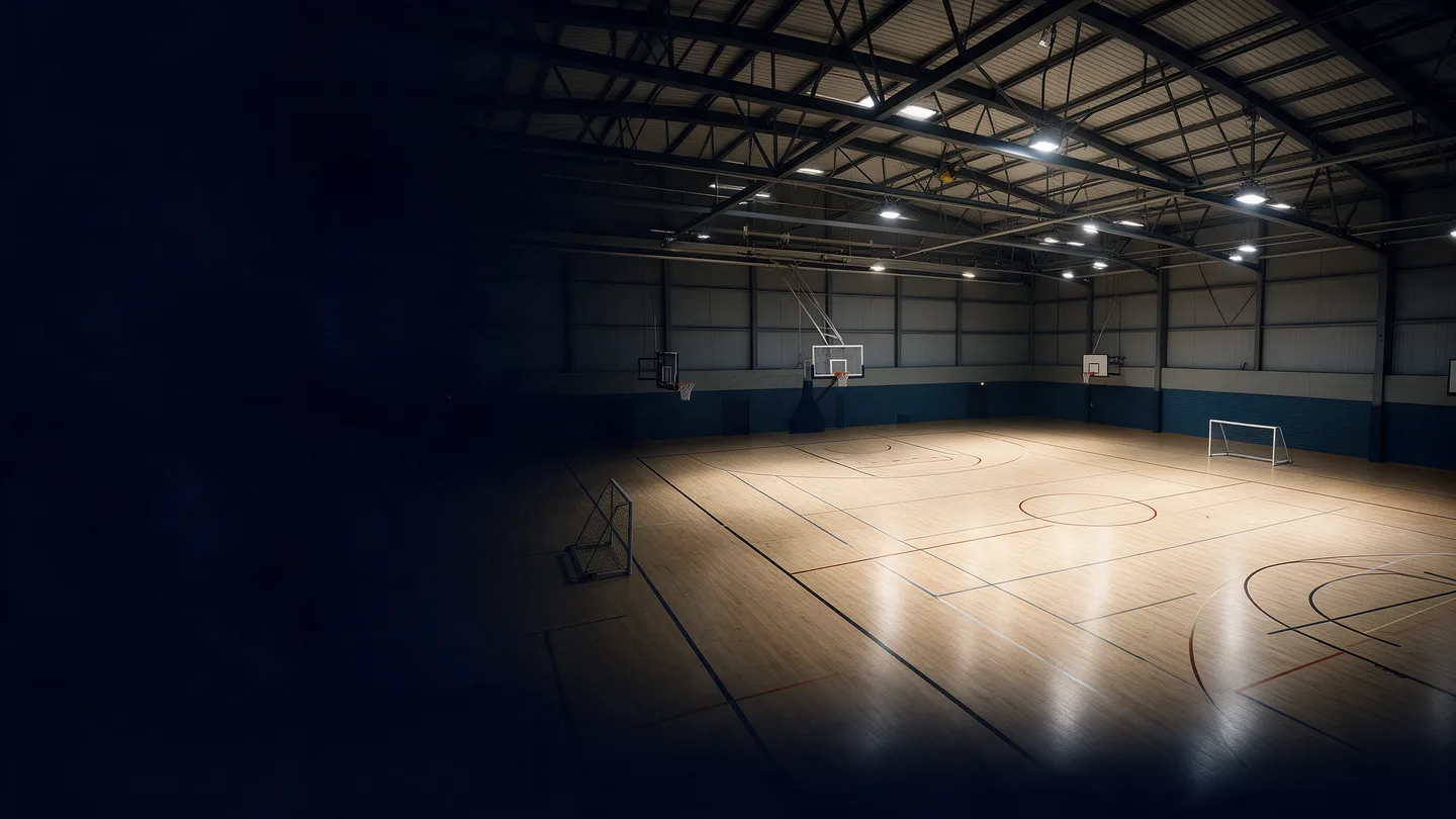 Visualisation d’un gymnase éclairé avec un sol en bois, des paniers de basket et des buts de futsal.
